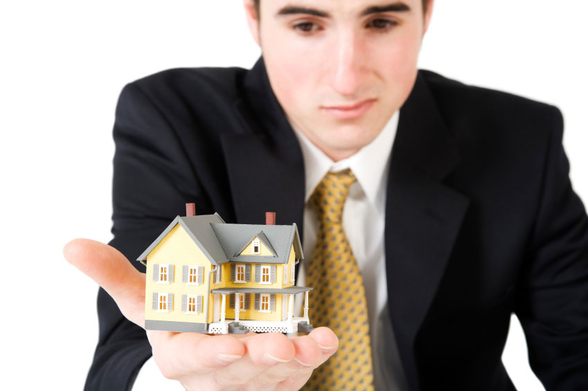 Landlord holding up a small model home in the palm of his hand